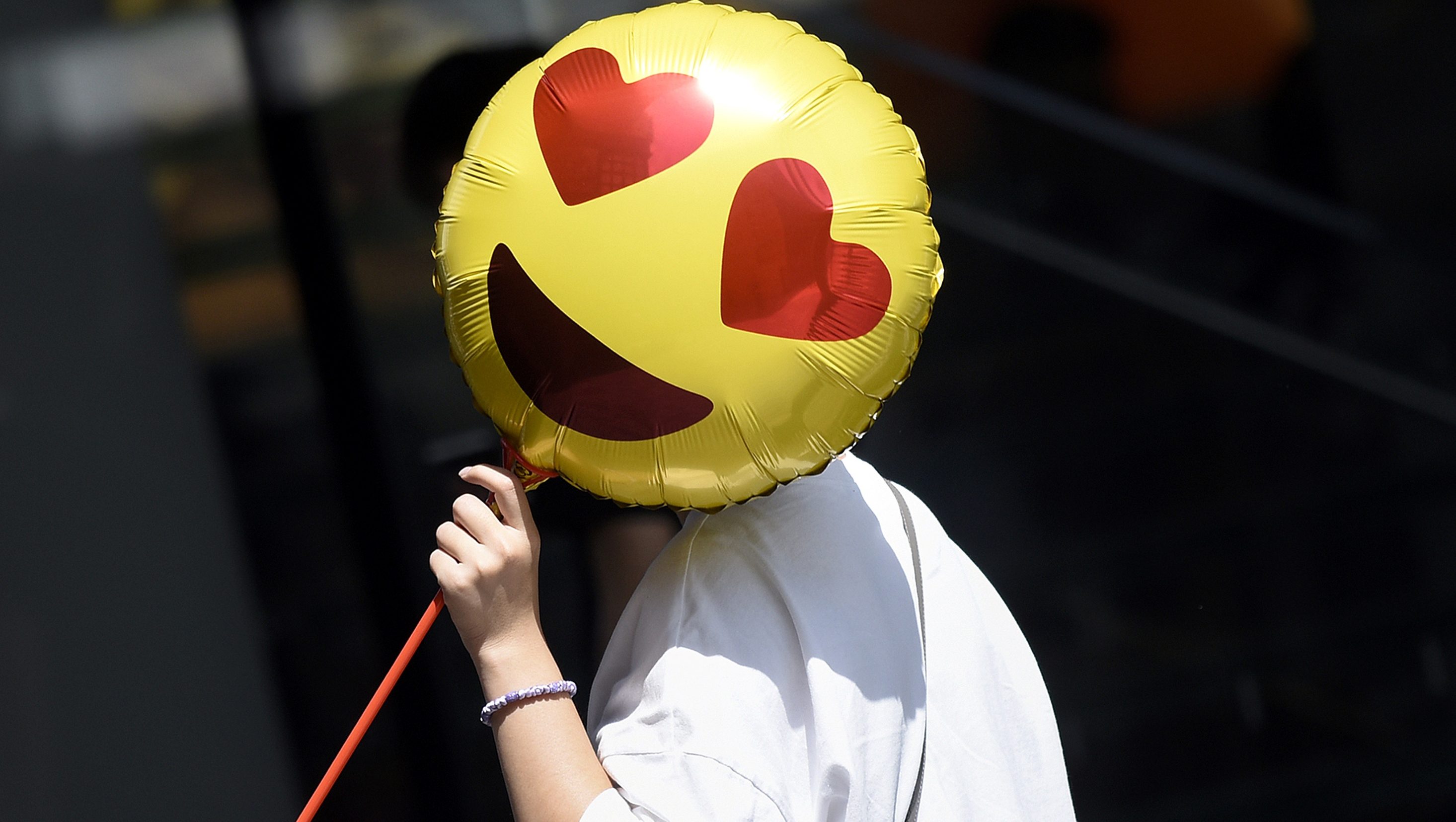 A woman holds a balloon as she walks past a store on Valentine's Day