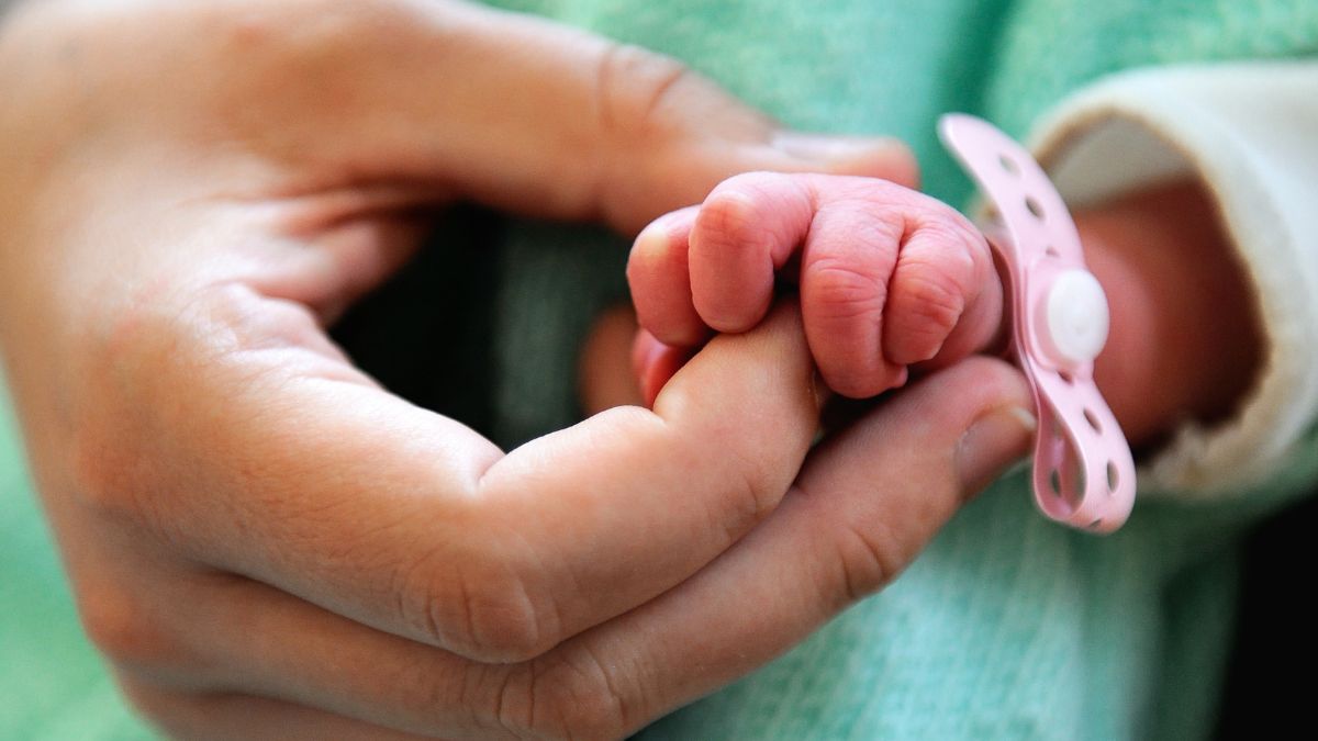 A baby holding a mother's hand