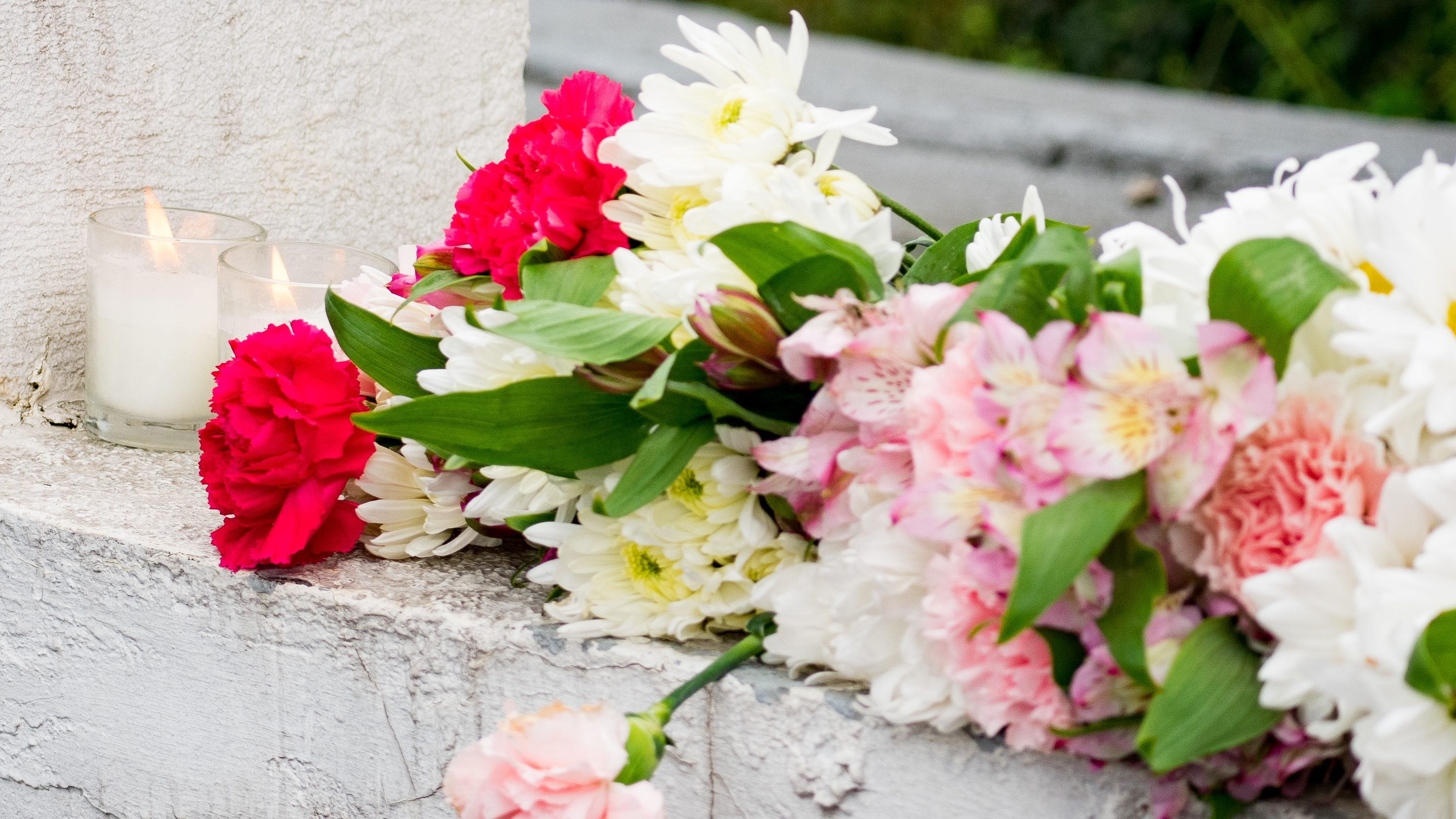 Flowers are placed at a memorial.