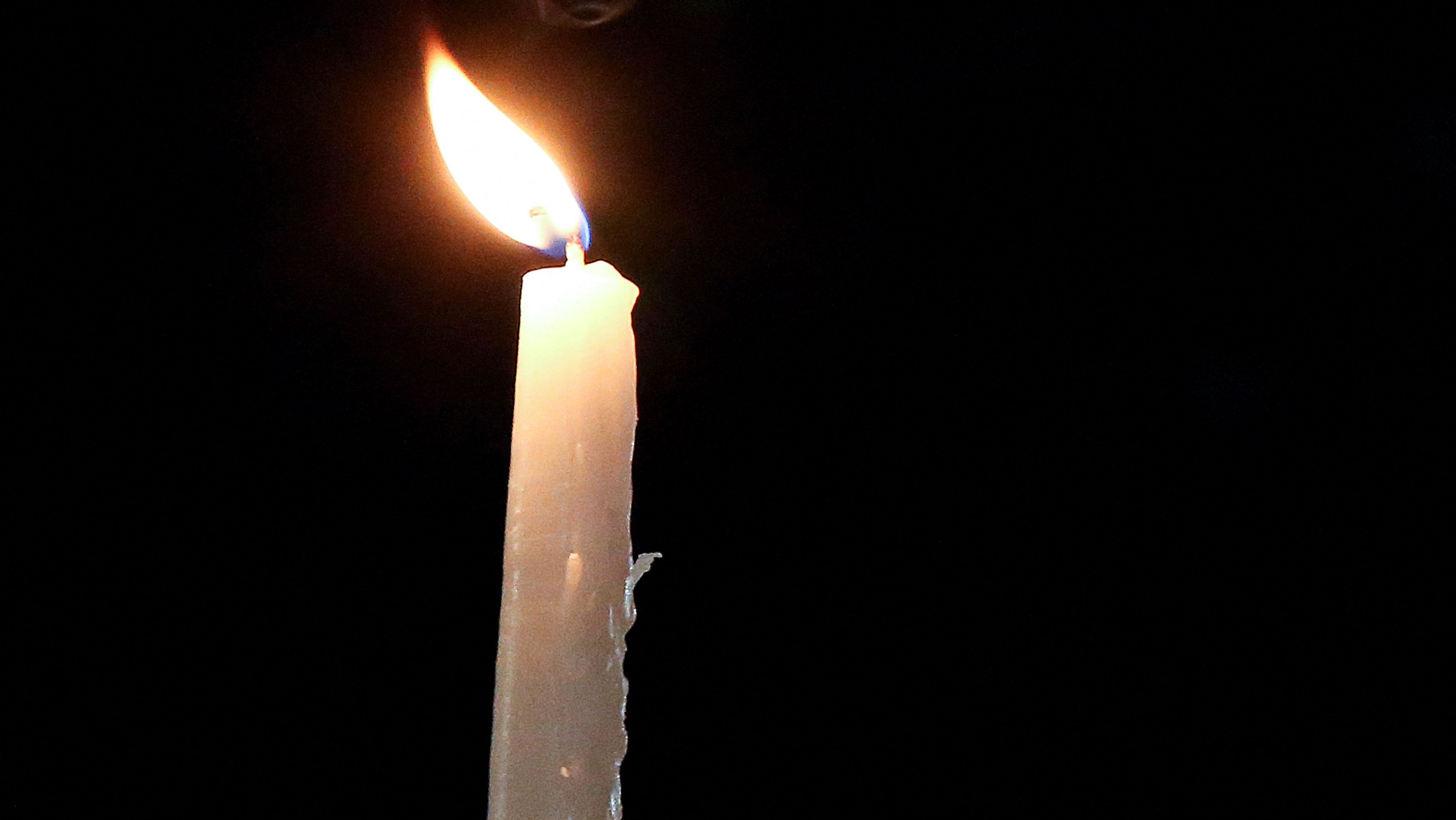 A memorial candle is lit.
