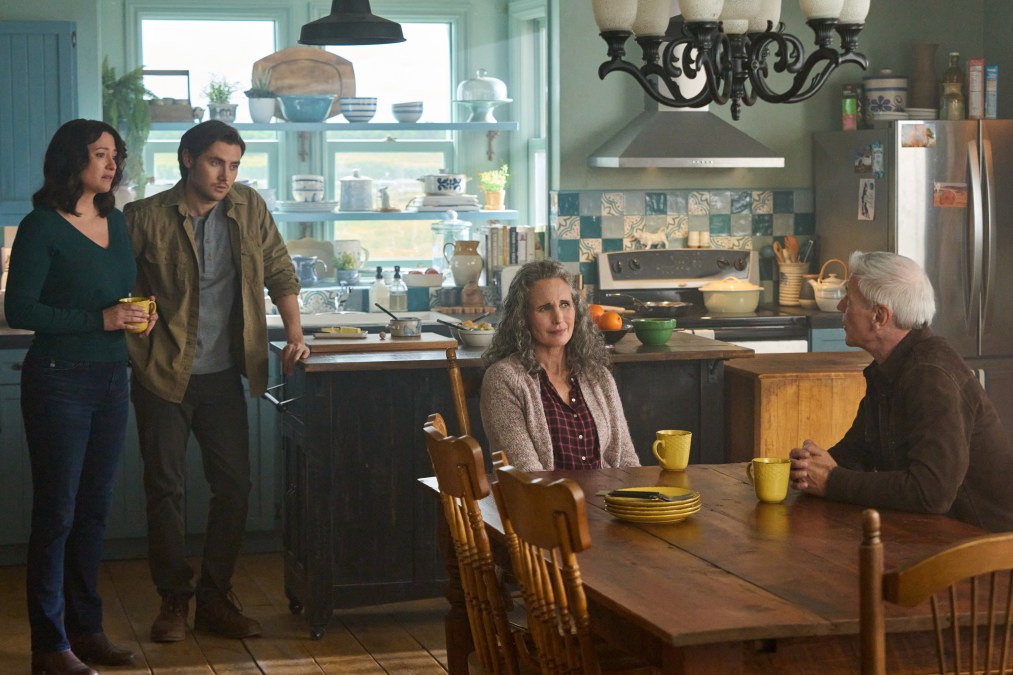 Kat and Jacob stand watching Del and Sam talking at the kitchen table.
