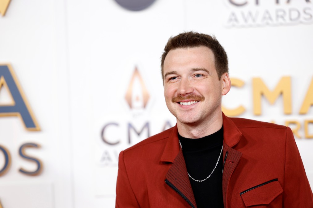 Morgan Wallen smiling in a red jacket