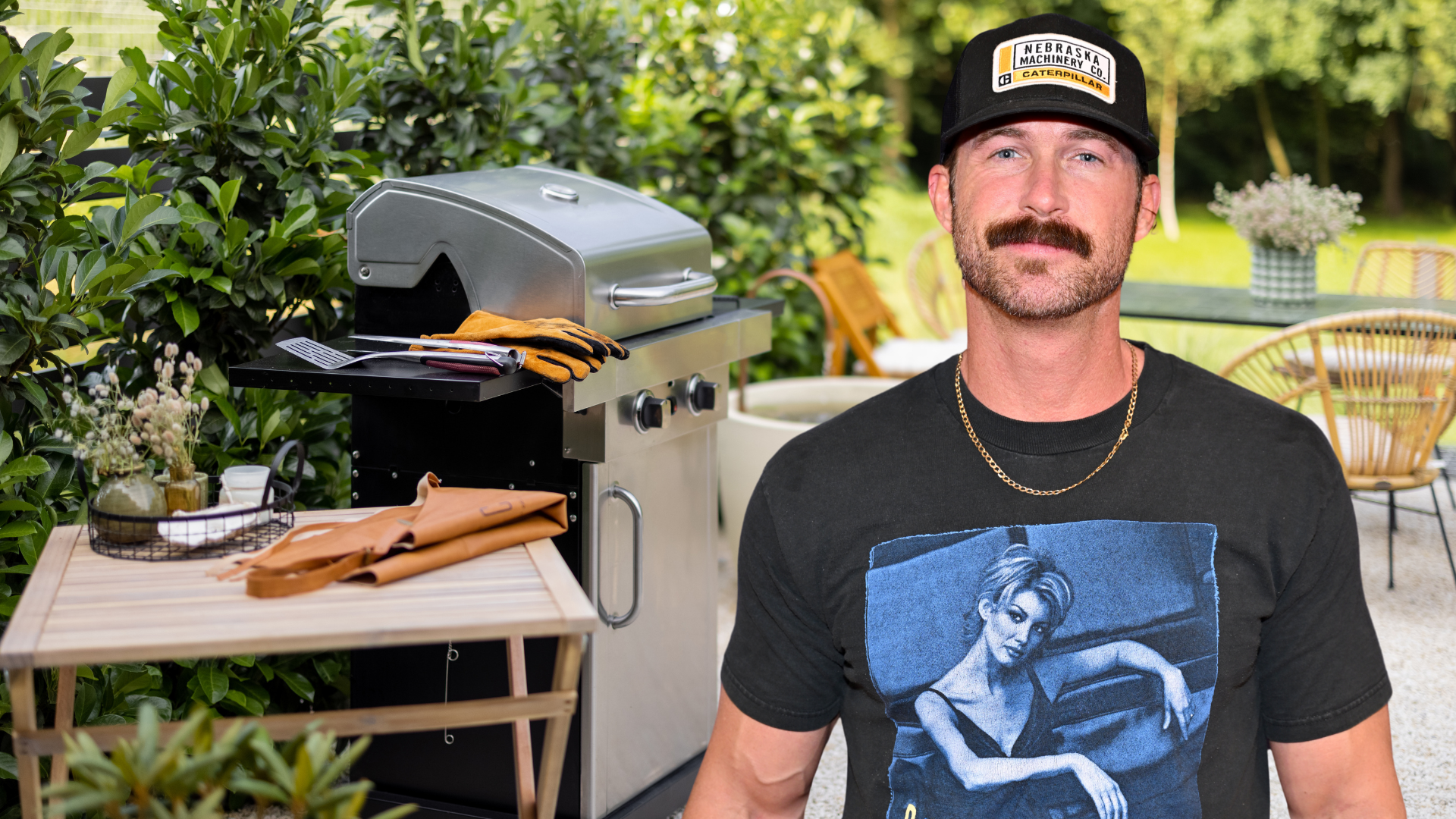 Riley Green posing in front of a grill