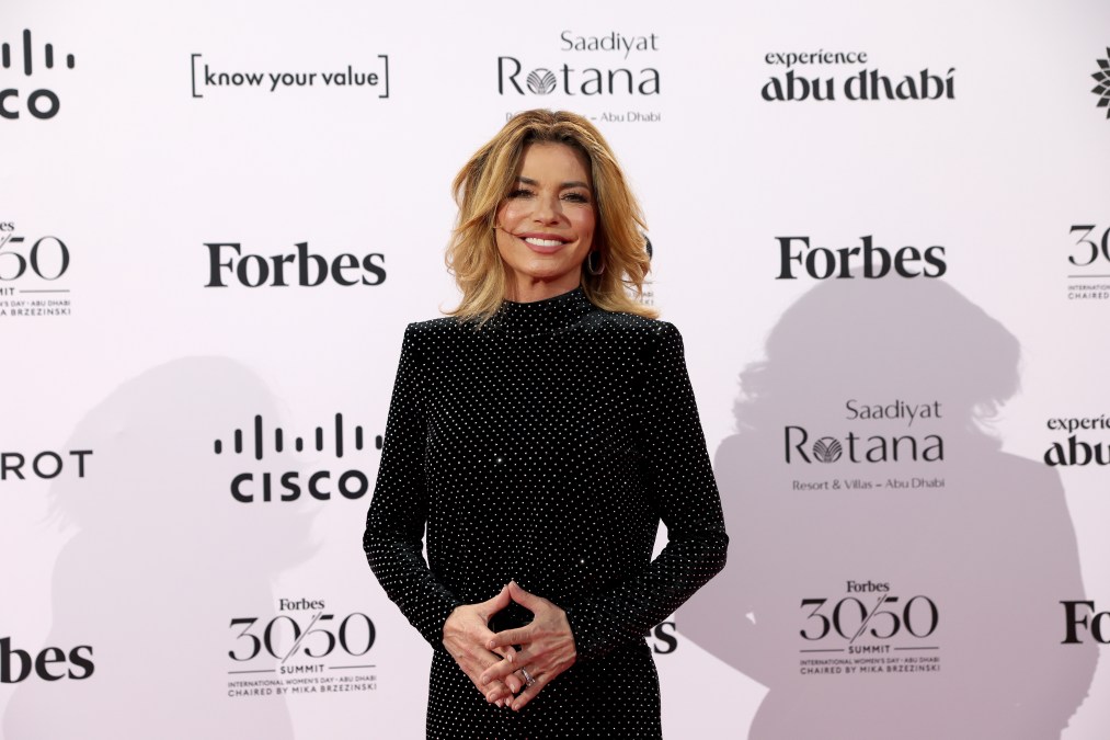 Shania Twain smiling in a black outfit.