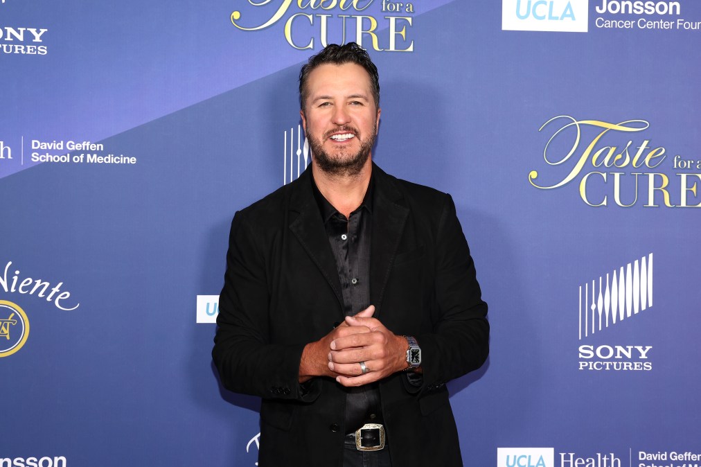 Luke Bryan posing in front of a step and repeat.