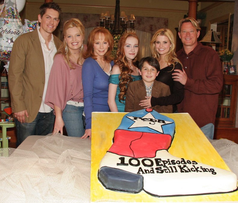 Reba McEntire and her 'Reba' castmates posing with a cake.