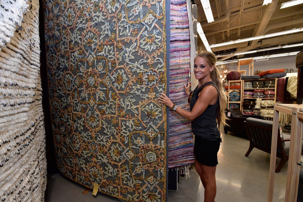 Nicole Curtis posing with rug samples.