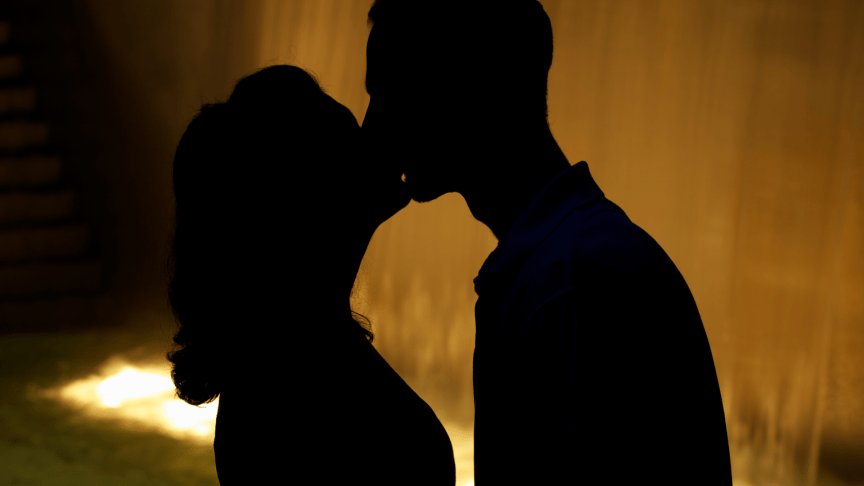 A man and woman kissing in silhouette