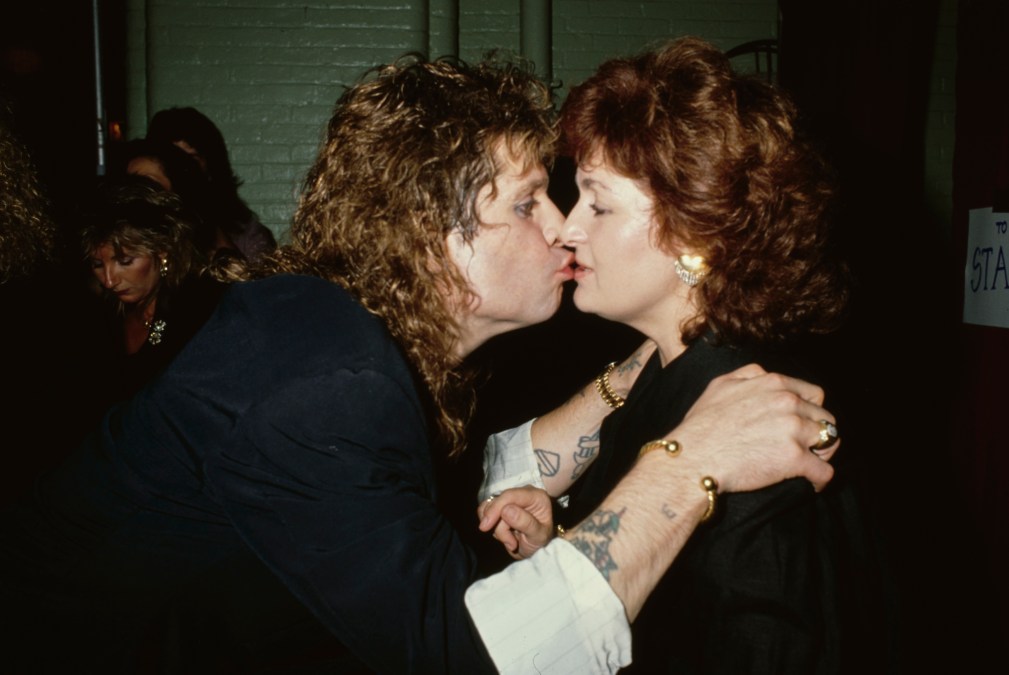 British singer and songwriter Ozzy Osbourne kisses his British manager and wife, Sharon Osbourne, circa 1985  