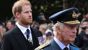 Britain's King Charles III and Britain's Prince Harry, Duke of Sussex walk behind the coffin of Queen Elizabeth II, adorned with a Royal Standard and the Imperial State Crown and pulled by a Gun Carriage of The King's Troop Royal Horse Artillery, during a procession from Buckingham Palace to the Palace of Westminster