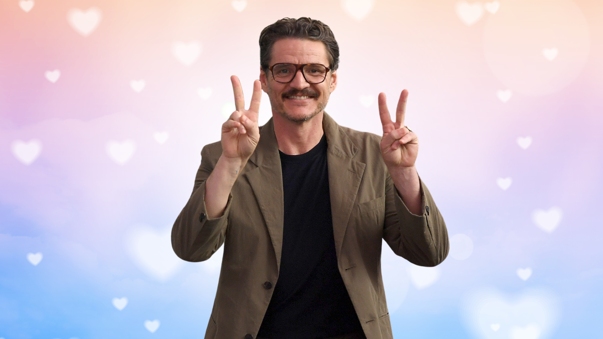 Pedro Pascal in front of a multi-colored hearts background