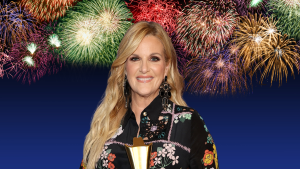 Trisha Yearwood posing with fireworks behind her.