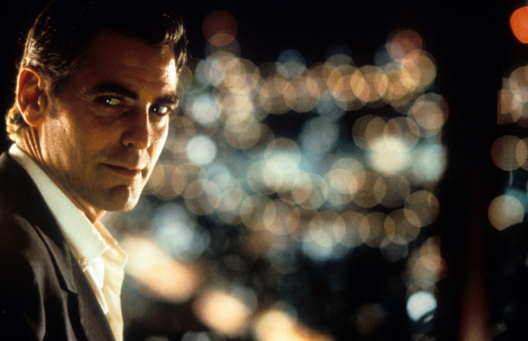 George Clooney looking to his right with the city lights as a backdrop in a scene from the film 'Out Of Sight', 1998.