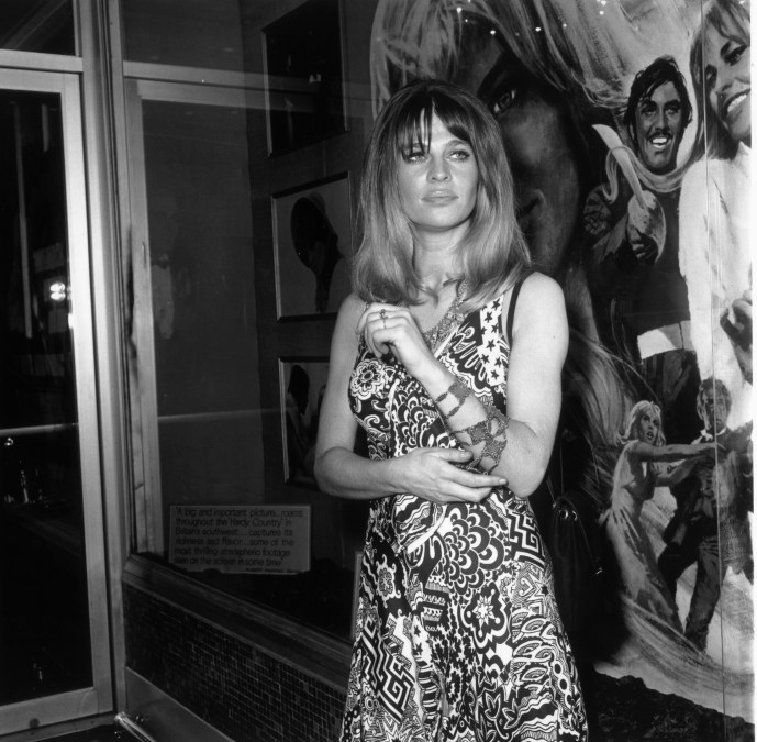 British actor Julie Christie stands in front of a poster for director John Schlesinger's film 'Far From the Madding Crowd'