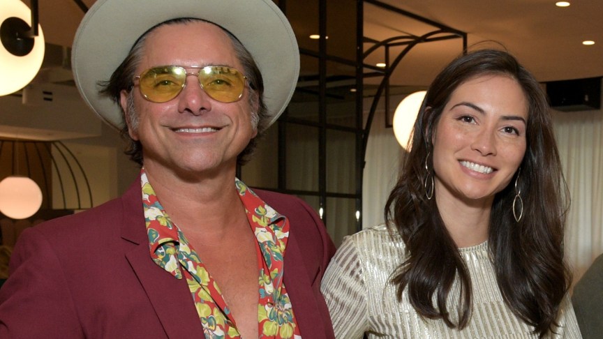 John Stamos and Caitlin McHugh smiling at an event