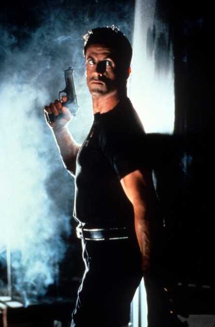Sylvester Stallone hiding behind a wall 